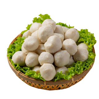 Basket of white meatballs on a bed of green lettuce leaves